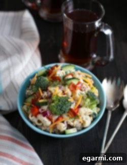 A close-up shot of the finished Cheddar Bacon Ranch Pasta Salad, showing creamy pasta, vibrant vegetables, bacon, and cheese.